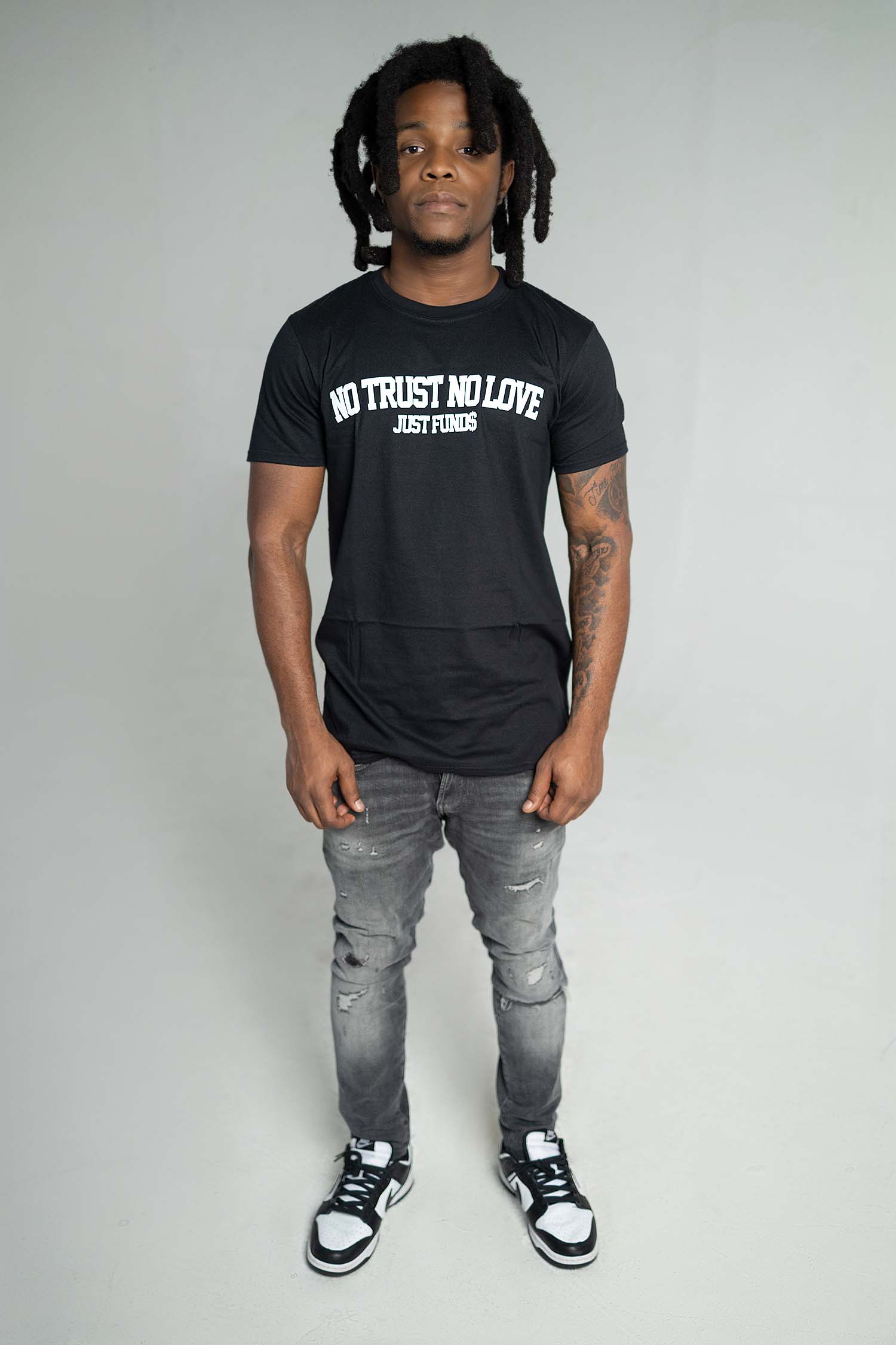 MALE MODEL WEARING SIZE S PLAIN BLACK NTNL JUST FUNDS TSHIRT