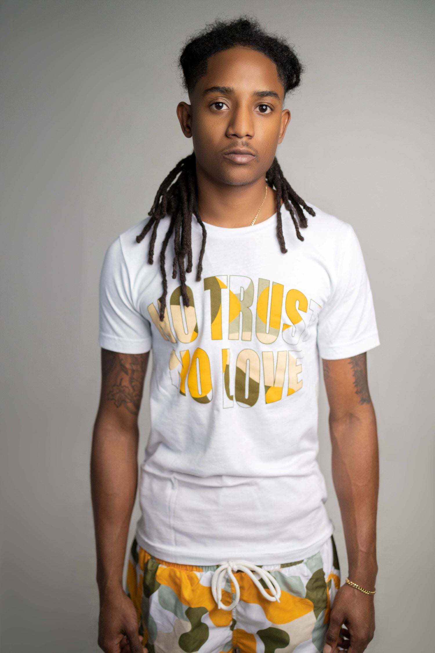 MODEL WEARING SIZE S GOLD CAMO NTNL PRINT ON PLAIN TSHIRT